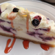 White chocolate blueberry cheesecake with raspberry drizzle